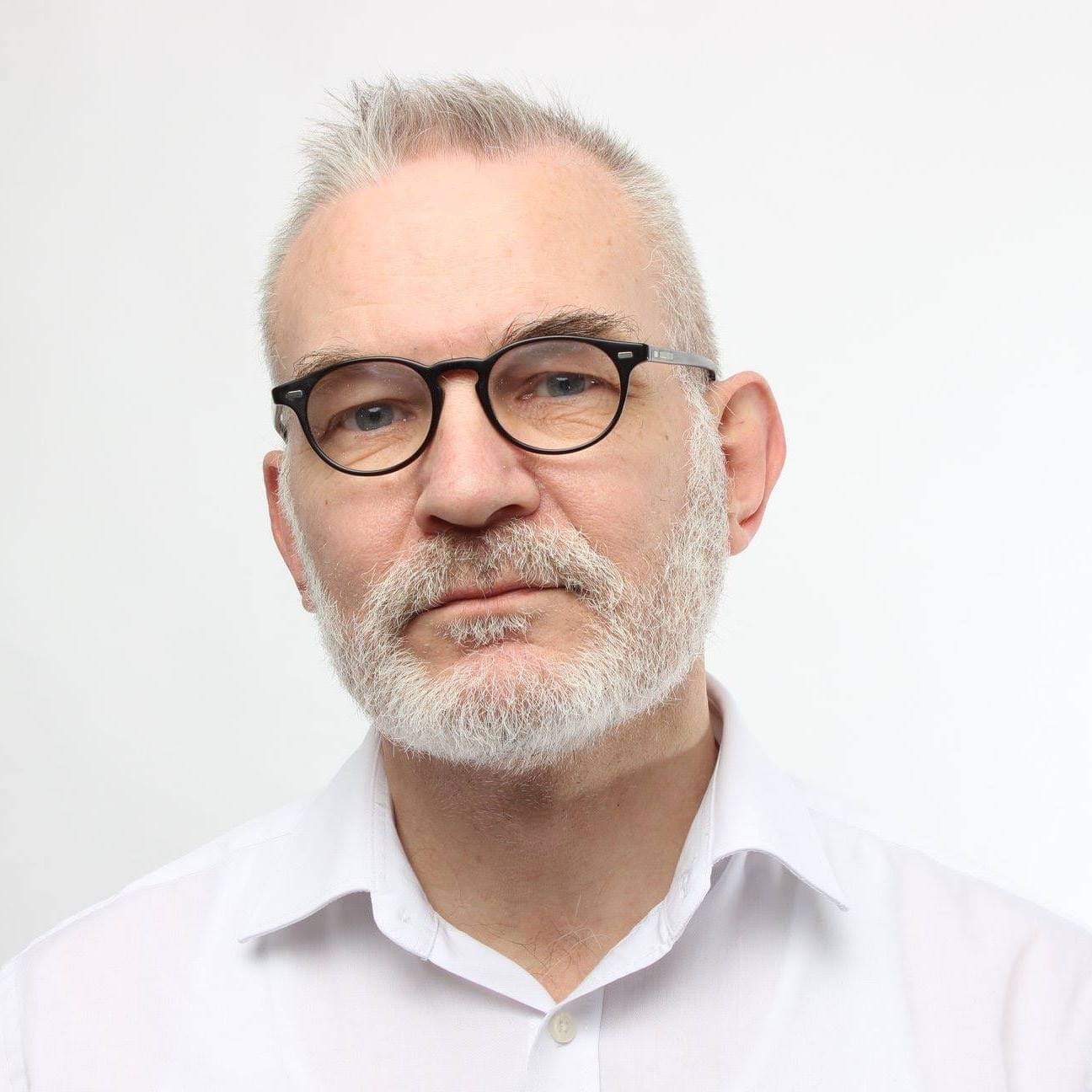 Andrew Boff pictured wearing a white shirt against a white background.