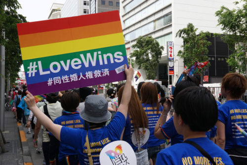 Person holding rainbow poster Love Wins for same-sex marriage rights among people marching in the Tokyo Rainbow Pride (TRP) Parade 2016 in Shibuya, Tokyo, Japan.